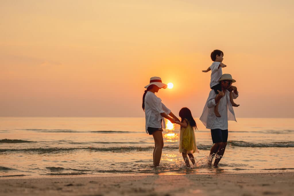 A family on the beach during sunset.