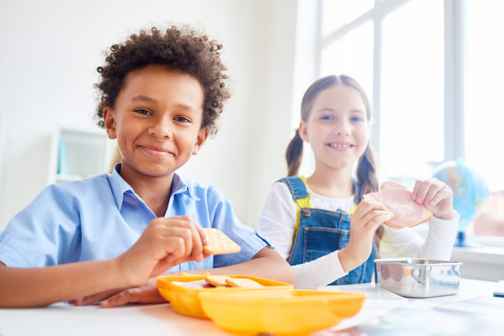 healthy snacks for kids. Modern schoolkids eating snacks from containers at break