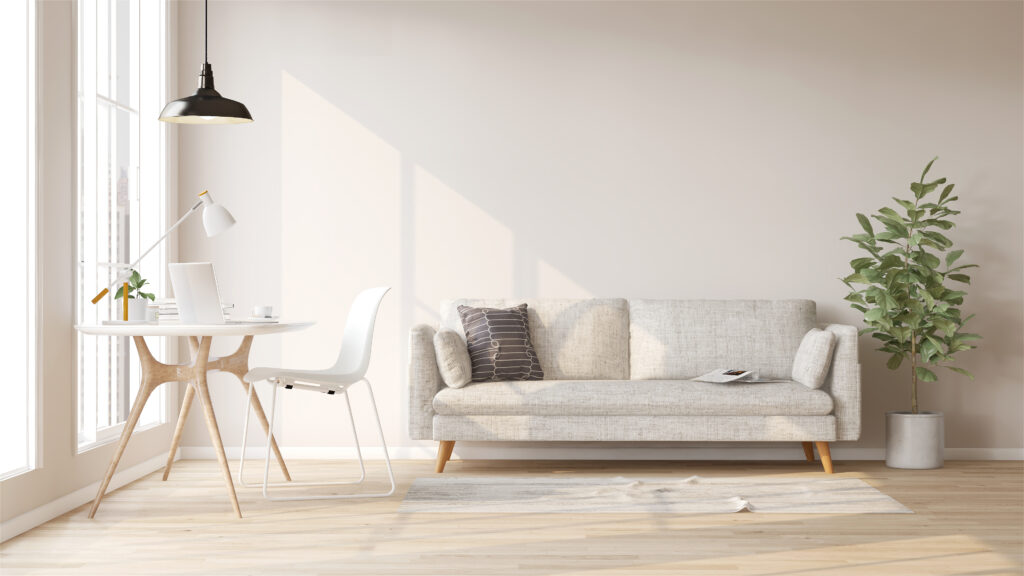 minimalist budget. White fabric sofa, fiddle leaf fig plant, wooden working desk and chair in modern and luxury creamed wall and parquet floor room with sunlight from window