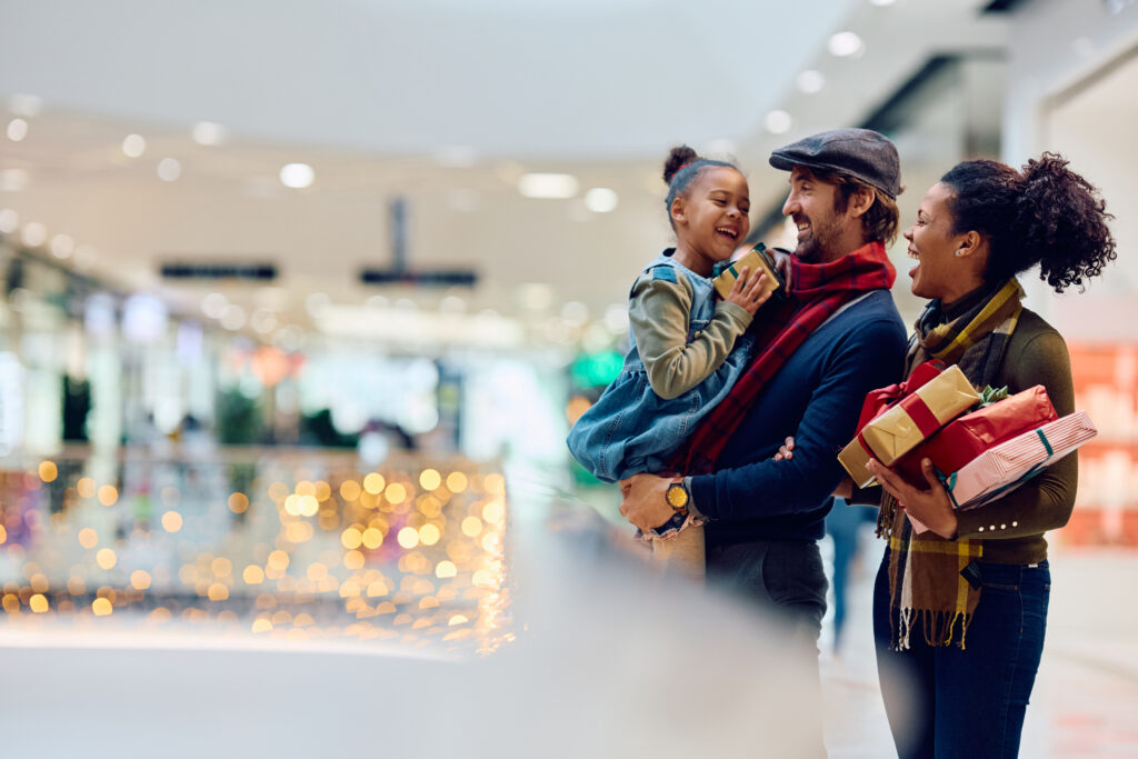 holiday shopping. Happy family having fun while buying Christmas presents at shopping mall. Copy space.